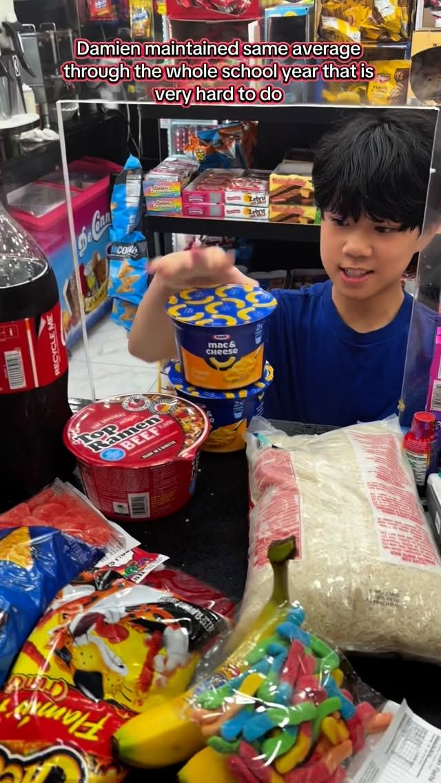 A student standing at a deli counter beside selected grocery items.