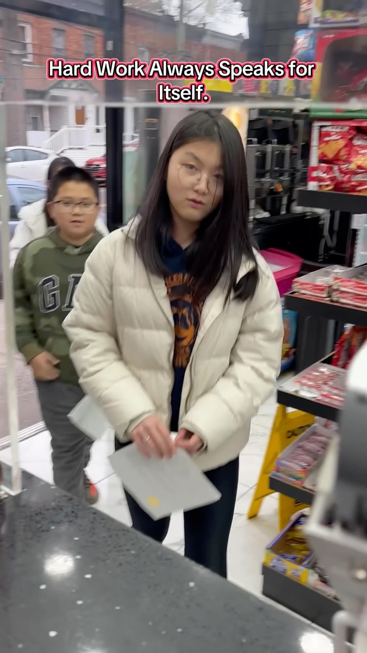 Two students arriving at a neighborhood deli, one holding a school paper.