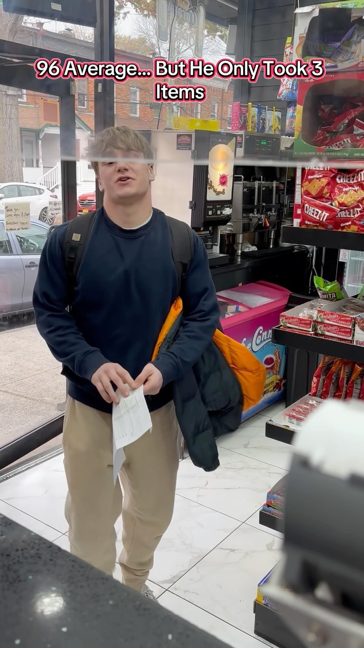 A student holding a school report at a deli counter.